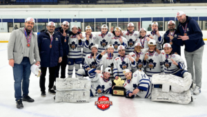 Ice hockey team posing on the rink with medals, trophy, and coaches after a playoff victory.